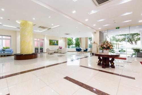 um grande lobby com uma mesa no meio em Bcons Riverside Hotel Binh Duong em Thu Dau Mot