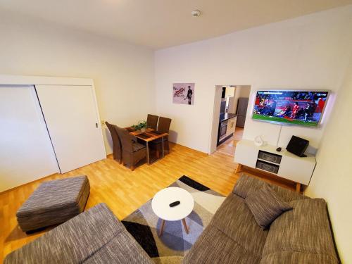 uma sala de estar com um sofá e uma televisão em VILLA LINDENECK ECONOMY em Bernburg