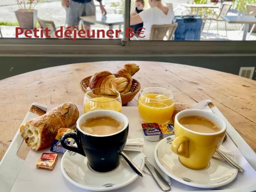 a tray with two cups of coffee and pastries on a table at Hotel Restaurant La Ceinture in Montcalm