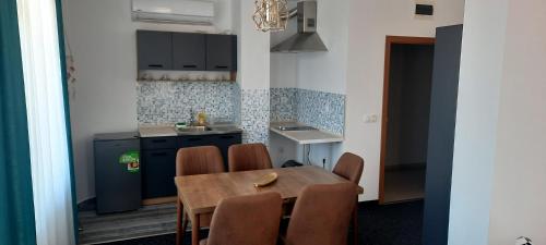 een keuken met een tafel en stoelen in een kamer bij Къща за гости Вивиан in Kiten