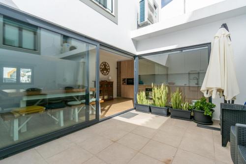 a glass extension of a house with plants at PÉ NA AREIA II by Stay in Alentejo in Vila Nova de Milfontes