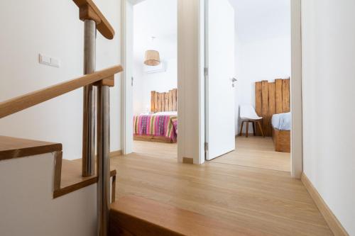 a hallway leading to a bedroom with a bed at PÉ NA AREIA II by Stay in Alentejo in Vila Nova de Milfontes