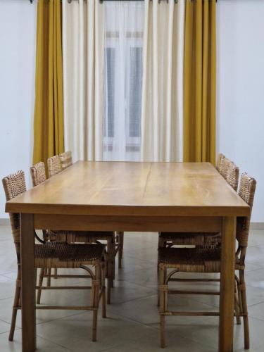 a large wooden table with chairs around it at Appartments Meuble SEED in Yaoundé