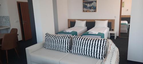 a living room with two beds and a couch at Къща за гости Вивиан in Kiten