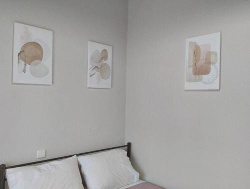 a bedroom with three pictures on the wall and a bed at Lovely Guesthouse On The Beach in Agia Anna