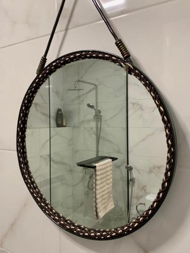 a round mirror with a shower in a bathroom at Мотель ''Ланівці'' in Lanivtsi