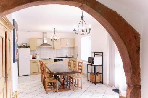 une voûte dans une cuisine avec une table et des chaises dans l'établissement Les Gîtes de la Mère Michèle, à Katzenthal