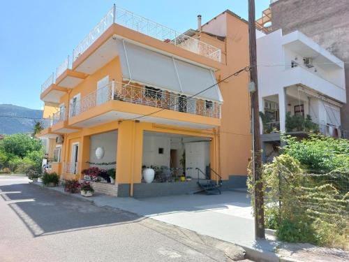 a yellow and white building with a balcony at Oranje Guesthouse in Itea