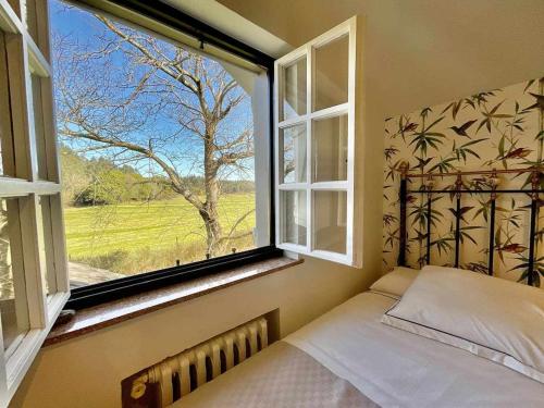 una camera con letto e finestra con vista di Casa Senda de los Miradores a Muros de Nalón