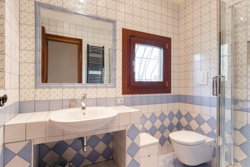 a bathroom with a sink and a toilet and a mirror at Villa Bagolini in Mentana