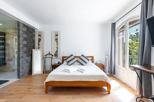 une chambre avec un lit et une grande fenêtre dans l'établissement Private & comfortable stone villa with pool, à Roquefort-les-Pins