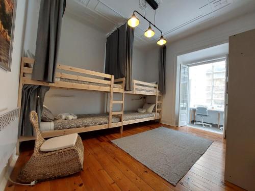a room with two bunk beds and a chair at Estrela Charming Rooms 2 by HOST-POINT in Lisbon