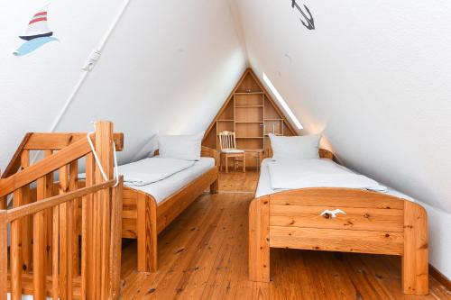 a attic bedroom with two beds and a staircase at Ferienwohnung Inselblick in Bensersiel