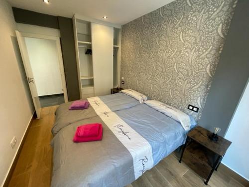 a bedroom with a large bed with a red pillow at Apartamento TROMPETA !!PARKING PRIVADO GRATUITO!! in Logroño