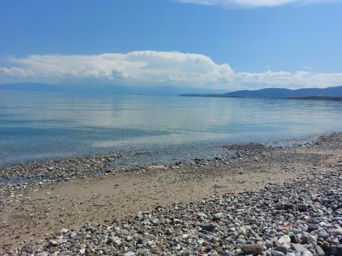 a rocky beach with the water and clouds in the sky at Oranje Guesthouse in Itea