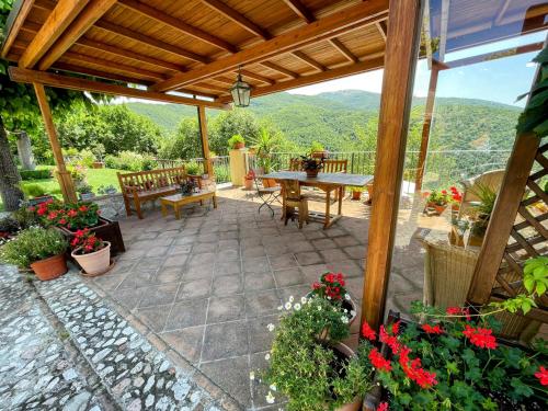 a patio with a table and chairs and flowers at Torretta sleeps 5 with pool and exclusive gardens plus private verandah in Strettura