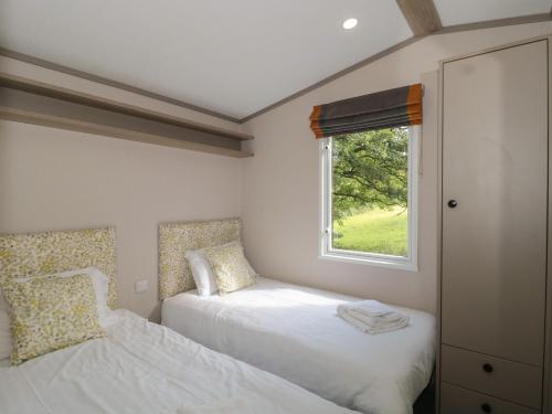 a bedroom with two beds and a window at Lodge 11 in Winscombe