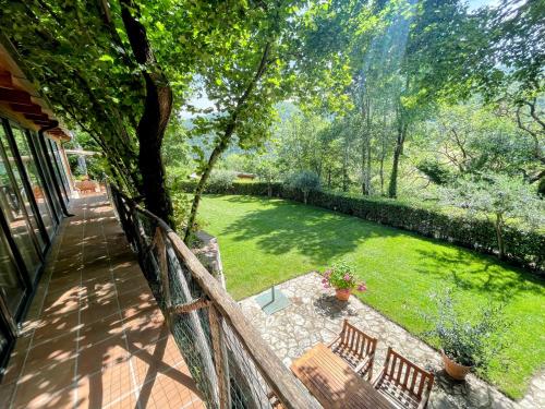 a view of a yard with two benches on a fence at Torretta sleeps 5 with pool and exclusive gardens plus private verandah in Strettura