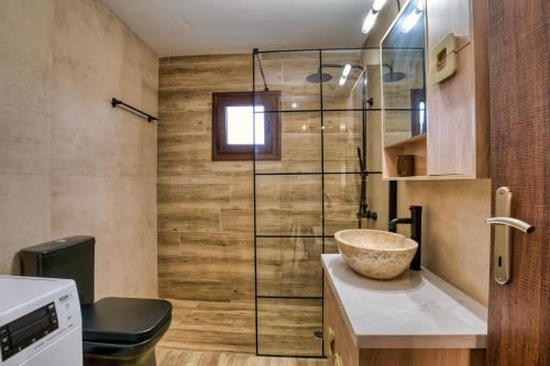 een badkamer met een wastafel en een glazen douche bij Cloud 9 with Garden near the Sea in Agia Pelagia