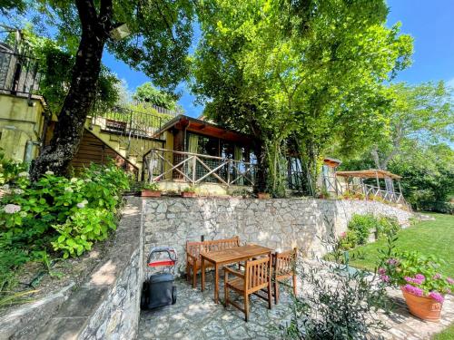 a house with a table and chairs and a stone wall at Torretta sleeps 5 with pool and exclusive gardens plus private verandah in Strettura