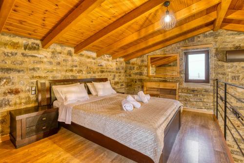 een slaapkamer met 2 bedden in een stenen muur bij Cloud 9 with Garden near the Sea in Agia Pelagia