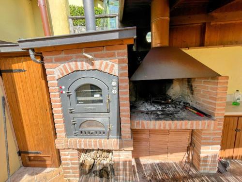 a brick fireplace with a stove in a house at Torretta sleeps 5 with pool and exclusive gardens plus private verandah in Strettura