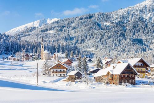 a village covered in snow with a mountain in the background at Almsternderl 2.0 - gemütliches Appartment in Gosau in Gosau