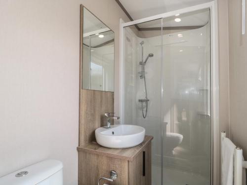 W łazience znajduje się umywalka i prysznic. w obiekcie Lodge 10 w mieście Winscombe