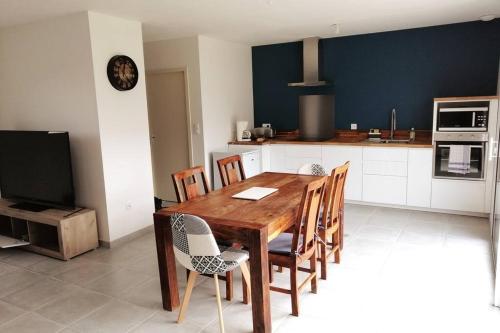 - une cuisine avec une table à manger en bois et des chaises dans l'établissement Maison située entre plage la mine d'or et bourg, à Pénestin