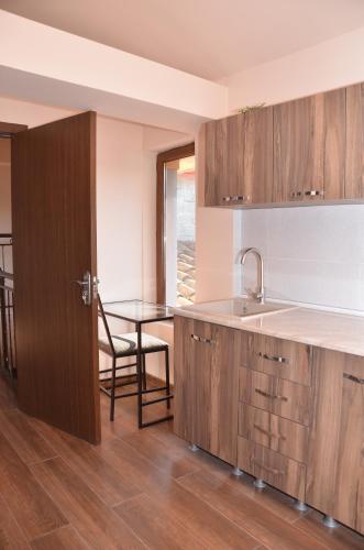 a kitchen with wooden cabinets and a table with a sink at Phudze in Tʼelavi