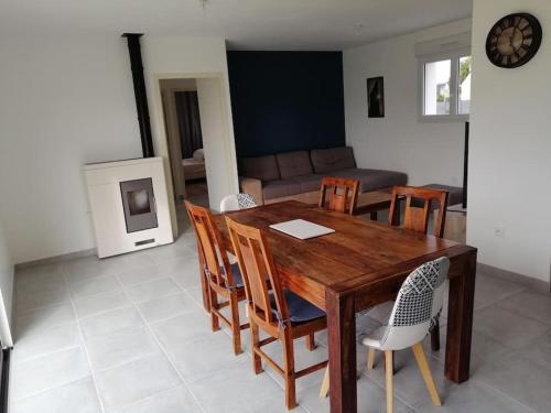 a dining room with a wooden table and chairs at Maison située entre plage la mine d'or et bourg in Pénestin