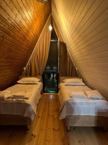 2 camas en una habitación con techo de madera en Heart of Surami, en Surami