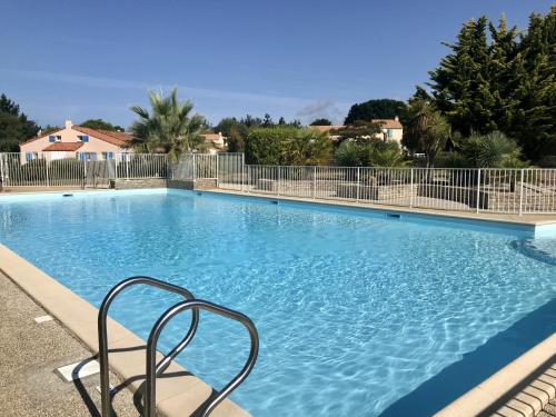 a large blue swimming pool with a chair in it at Maison avec piscine à 200m de la plage in Saint-Michel-Chef-Chef