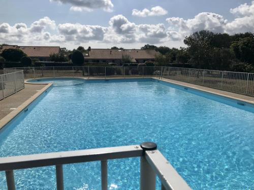a large swimming pool with blue water at Maison avec piscine à 200m de la plage in Saint-Michel-Chef-Chef