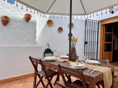 a dining room with a table with chairs and an umbrella at Apartamento Rubire in Vejer de la Frontera