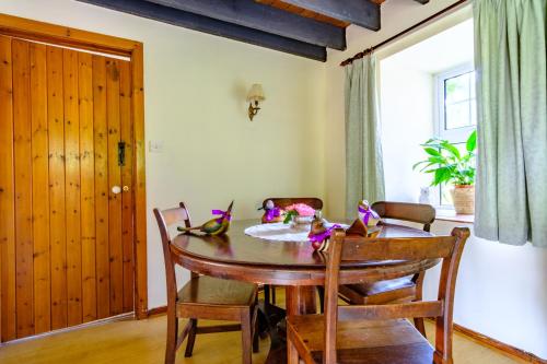 a dining room with a wooden table and chairs at Lakeside Cottage in Carmarthen