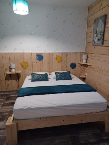 a bedroom with a large bed with blue pillows at Le Refuge in Saint-Aignan