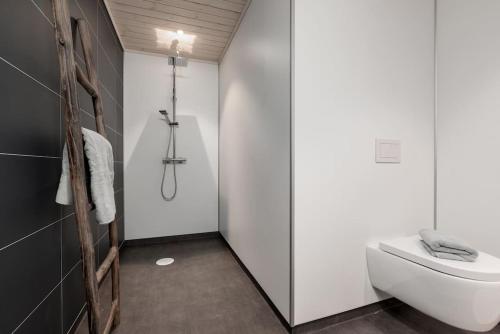a bathroom with a white toilet and a shower at Hodlekvevegen 308 - Flott hytte midt i skisenteret in Sogndal