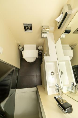 La petite salle de bains est pourvue de toilettes et d'un lavabo. dans l'établissement Hotel Düsseldorfer Hof, à Francfort-sur-le-Main