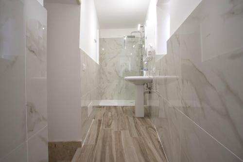 biała łazienka z umywalką i prysznicem w obiekcie Terre d'oro, appartamento di lusso in centro città w mieście Palermo