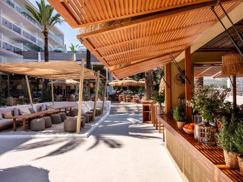 an outdoor patio with tables and umbrellas at Zel Mallorca in Palmanova