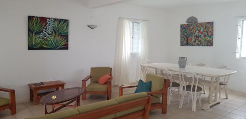 ein Wohnzimmer mit einem Tisch und Stühlen sowie ein Esszimmer in der Unterkunft Turquoise in Blue Bay