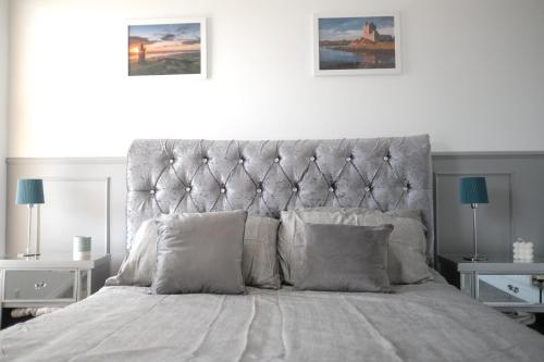 una camera bianca con un grande letto con cuscini di Eia Street Apartments Belfast a Belfast
