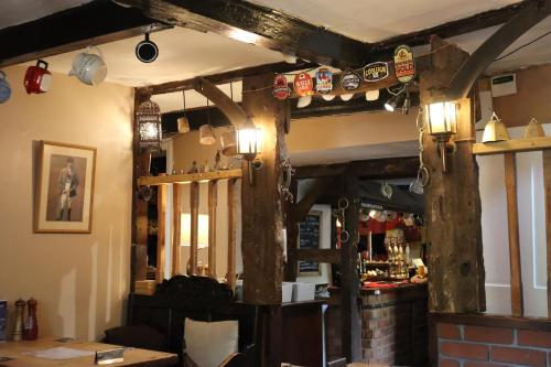 Un comedor con vigas de madera y un bar. en The White Horse Inn, en Washford