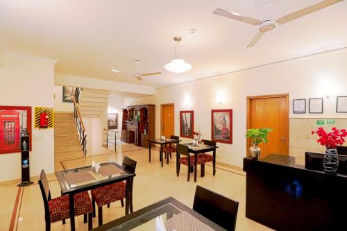 una sala de estar con mesas y sillas y un comedor. en Ahuja Residency Cyber City I, en Gurgaon