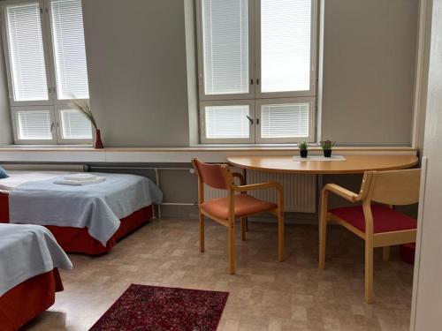 Zimmer mit einem Tisch, Stühlen und einem Bett in der Unterkunft Tapanilan Huoneistot in Lahti