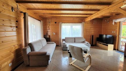 ein Wohnzimmer mit 2 Sofas und einem TV in der Unterkunft Dom Derbend in Sztutowo