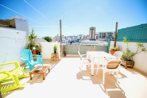 a patio with chairs and a table on a roof at Prime location: 3 Bedroom/3 Bath+Terrace in St. Julianʼs