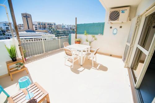 a patio with a table and chairs on a balcony at Prime location: 3 Bedroom/3 Bath+Terrace in St. Julianʼs