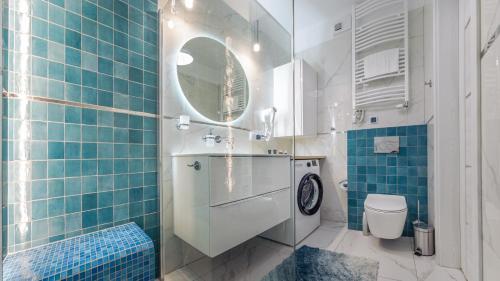 a bathroom with a sink and a toilet and a mirror at Apartament Akwamaryn A 309 przy plaży- Perłowa Przystań- Holiday City in Sianozety